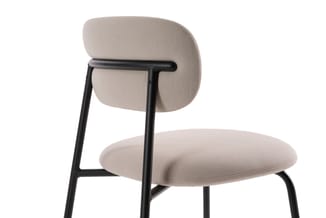 Grijsbeige stoel met rond zitgedeelte, gebogen rugleuning en zwart metalen frame, getoond in zijaanzicht.