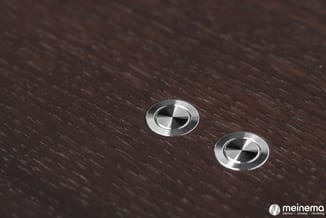 Twee ronde, inbouw spotlights met metallic afwerking in donkerbruin houtoppervlak.