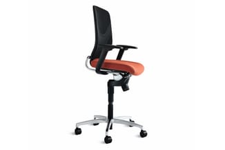 Ergonomische bureaustoel met zwarte netrug, oranje zitje, zwarte armleuningen en zilveren onderstel op wielenset tegen witte