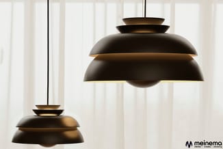 Twee zwarte hangende lampen met gelaagde koepelvormige schermen en goudkleurige binnenzijden tegen een licht gordijn.