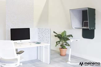 Modern kantoorwerkplek met wit bureau, zwarte monitor, witte akoestische scheidingswand, grijze bureaustoel, potplant en zwar