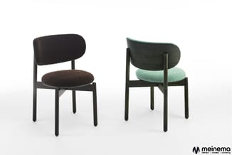 Twee stoelen met zwart houten frame: links zwarte stof, rechts groen geruit patroon met groene rug. meinema logo rechtonder.