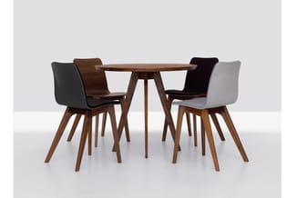 Ronde houten tafel met vier stoelen in verschillende kleuren (zwart, donkerblauw, grijs), houten poten, moderne minimalistisc
