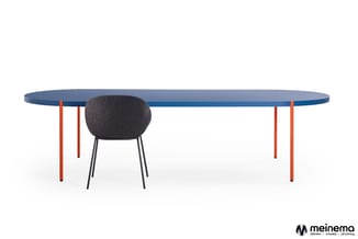 Ovale vergadertafel met blauwe tafelblad en rode poten, met zwarte stoelbekleding daaronder.