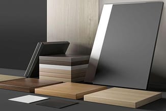 Houten materiaalstalen in verschillende kleuren en finishes, getoond met grijze panelen en stalen samples op grijs oppervlak.