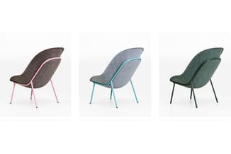 Drie stoelen in verschillende kleuren: donkergrijs met roze poten, lichtgrijs met turquoise poten, en groen met donkergroene