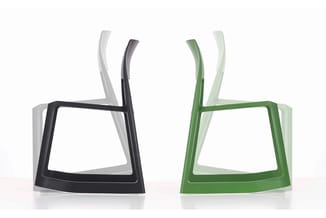Moderne stoelen in zwart en groen met witte varianten, gestapeld weergegeven met gebogen rugleuning en rechthoekige zitting.