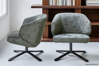 Twee grijze gestoffeerde draaifauteuils met zwart kruisvoetframe tegen houten kastenwand met boeken.