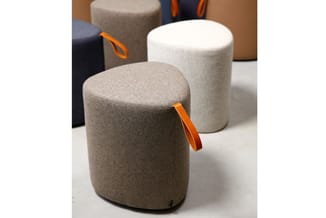 Cylindrische poefjes in beige, wit en donkerblauw met oranje handgrepen, op witte ondergrond.