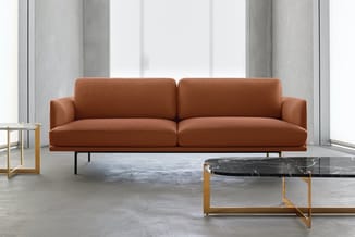Cognac lederen bank met twee zitplaatsen, metalen poten, staande in moderne kantoorruimte met marmeren salontafel en gouden f