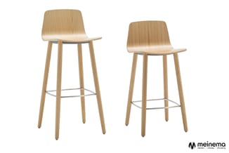Twee houten barkrukken met gebogen zitting, houten poten en metalen voetsteun, tegen witte achtergrond.