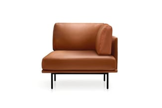 Bruine leren loungestoel met hoge rugkussens en zwarte metalen poten op witte achtergrond.