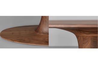 Houten vergadertafel met walnootfineer, organische vormen en gebogen poten, zijaanzicht op neutrale achtergrond.