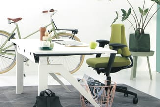 Modern kantoor met groene bureaustoel, wit bureau, groen fietsen en plantenbak, grijze vloer en accessoires.