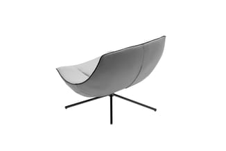Grijze loungefauteuil met gebogen zitting, zwart metalen driepotig onderstel, vrijstaand tegen witte achtergrond.