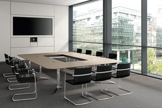 Moderne vergaderzaal met U-vormige tafel in beige, zwarte kantorstoelen met chromen frames, wandmonteerde TV, grote raamparti