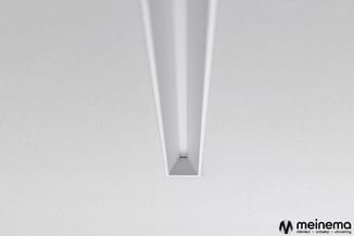 Witte plafondprofiel met ingebouwde LED-verlichting in rechthoekig aluminium kanaal, geïnstalleerd in wit plafond.