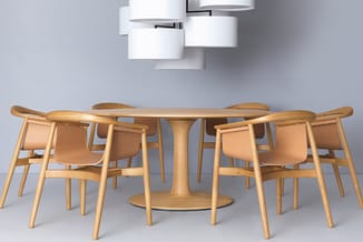 Houten ronde vergadertafel met natuurlijk fineer en zes houten stoelen met beige bekleding, onder moderne witte plafondlampen