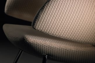 Beige bureaustoel met gewatteerde zitting en rugleuning, textielafwerking, detail van stoffen oppervlak.