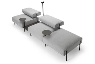 Modulaire grijze bankset met afneembare rugkussens, zwarte metalen poten en bijzettafels, in L-vormige opstelling.
