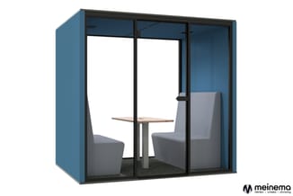 Blauwe akoestische belcel met zwart aluminium frame, glazen deuren, grijze stoelen en houten tafel binnenin.
