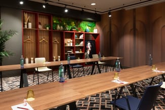 Moderne vergaderruimte met houten vergadertafels, zwarte stoelen, rode kastenwand met groene plantenmuur, houten lamellen, pa