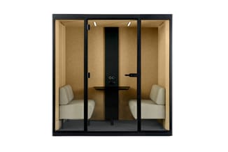 Akoestische belcel met zwart frame, beige wanden, grijze vloer, twee beige stoelen, zwarte tabel met monitorarm en verlichtin