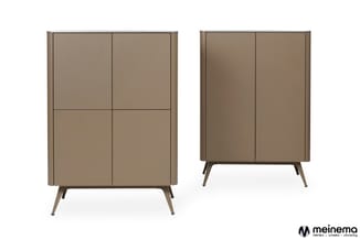 Twee grijsbruine kasten met deuren en horizontale indeling, op schuine poten. Meinema-logo rechtsonder.