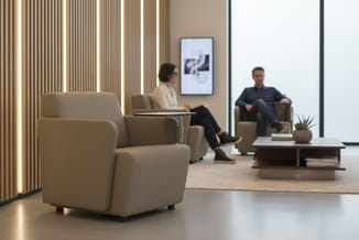 Moderne kantoorkamer met beige fauteuils, houten tafel, potplanten, digitaal scherm aan muur, verticale ledverlichting en twe