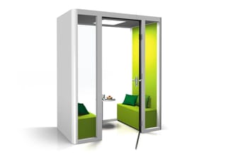 Witte belcel met groene binnenkant, schuifdeuren, zitbank met groene kussens en klein tafeltje met kopjes.