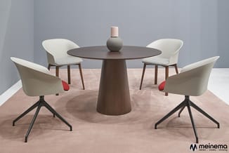 Ronde donkerhouten vergadertafel met vier draaistoelen in crème en beige met rode details, op zandkleurig tapijt in moderne k