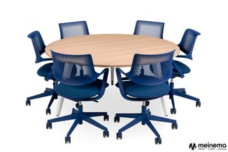 Ronde vergadertafel met licht houtfineer, omringd door zes blauwe bureaustoelen met meshrug en wieltjes.