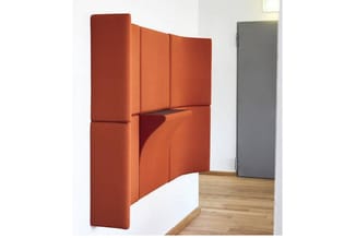 Oranje akoestische wanden in L-vorm opgesteld in een kantoorruimte met houten vloer en grijze kastenwand.