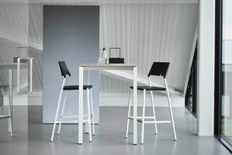 Modern kantoor met wit statafel en twee bijpassende barkrukken met zwarte zitting in minimalistisch design.