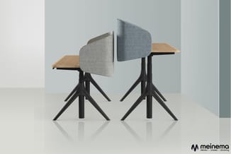 Twee moderne vergaderstoelen met grijze stofbekleding, licht houten zitting en zwart metalen kruispotige onderstel, tegen lic
