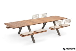 Houten vergadertafel met grijze poten, vier witte stoelen met kussens en houten zitbank met kussens, tegen witte achtergrond.