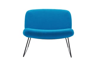 Blauwe loungefauteuil met afgeronde vormen, zitgedeelte met kussen en rechthoekige rugleuning, zwarte metalen poten.