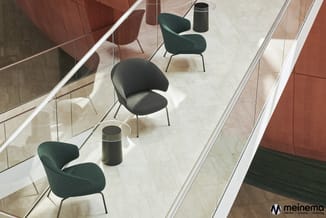 Moderne kantoorruimte met groene en grijze stoelen, zwarte poefs en glazen wanden, marmeren vloer.