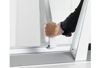 Hand opent schuifdeur van wit aluminium frame met glazen paneel in kantooromgeving.