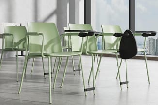 Groene stapelstoelen met armleuningen en zwarte details rond een vergadertafel in modern kantoor met grote ramen en stadsuitz