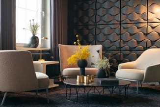 Moderne lounge met twee beige stoelen, zwart salontafel, zwarte 3D-wandpanelen, gele bloemen in vazen en raam met gordijnen.