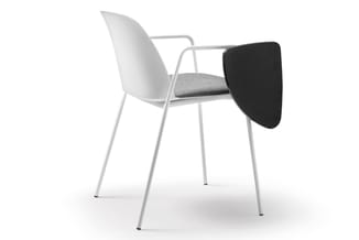 Witte stoel met grijze zitting, metalen frame, armsteunen en zwarte bijzettafel aan de rechterzijde.