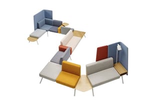 Modulair zitlandschap met grijze, beige, rode en gele zitelementen, houten details en metalen poten, bovenaanzicht.