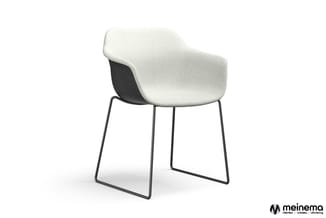 Moderne stoel met crème-wit gestoffeerde zitting, zwarte kunststof rug en zwart metalen framebasis op sledepoten.