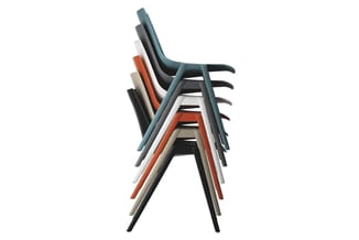 Gestapelde kantooorstoelen in verschillende kleuren: blauwgrijs, zwart, wit, oranje en beige met zwarte poten en armsteunen.