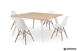 Eettafel met lichte houten blad en witte poten, omgeven door vier witte stoelen met houten poten en zwarte details.