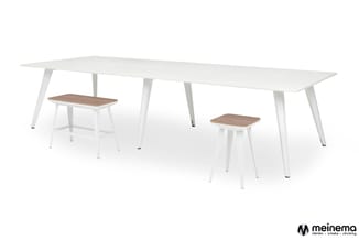 Witte vergadertafel met twee houten krukken eronder, moderne minimalistische kantoorinrichting.