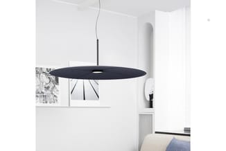 Zwarte hanglamp met elliptische vorm boven kantoorruimte met wit interieur, bureau en blauwe kussens zichtbaar.