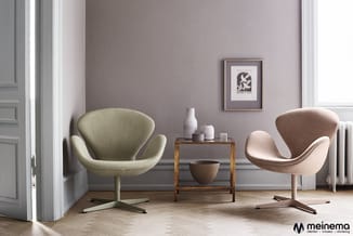 Twee moderne fauteuils in groen en beige met X-poot, houten bijzettafel, minimalistisch ingerichte ruimte met paarse muur.