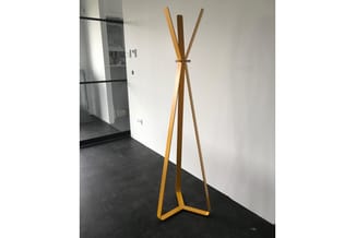 Houten kapstok met driehoekig onderstel en drie verticale staven, natuurlijke houtkleur, staande in een kantoor met betonnen